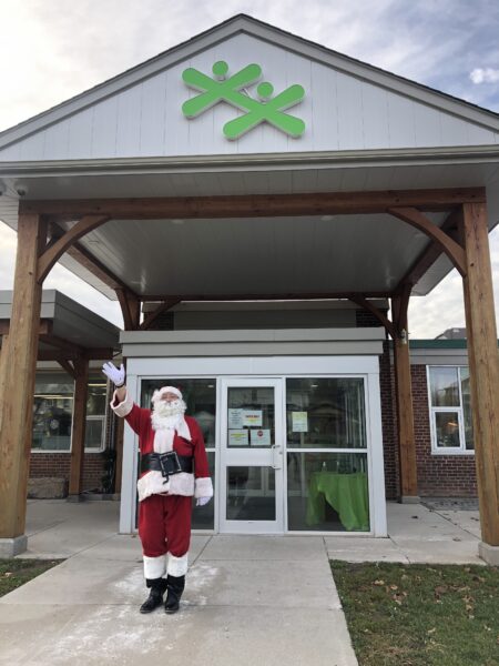 Santa Claus standing in front of the Boys and Girls Club of Kawartha Lakes building